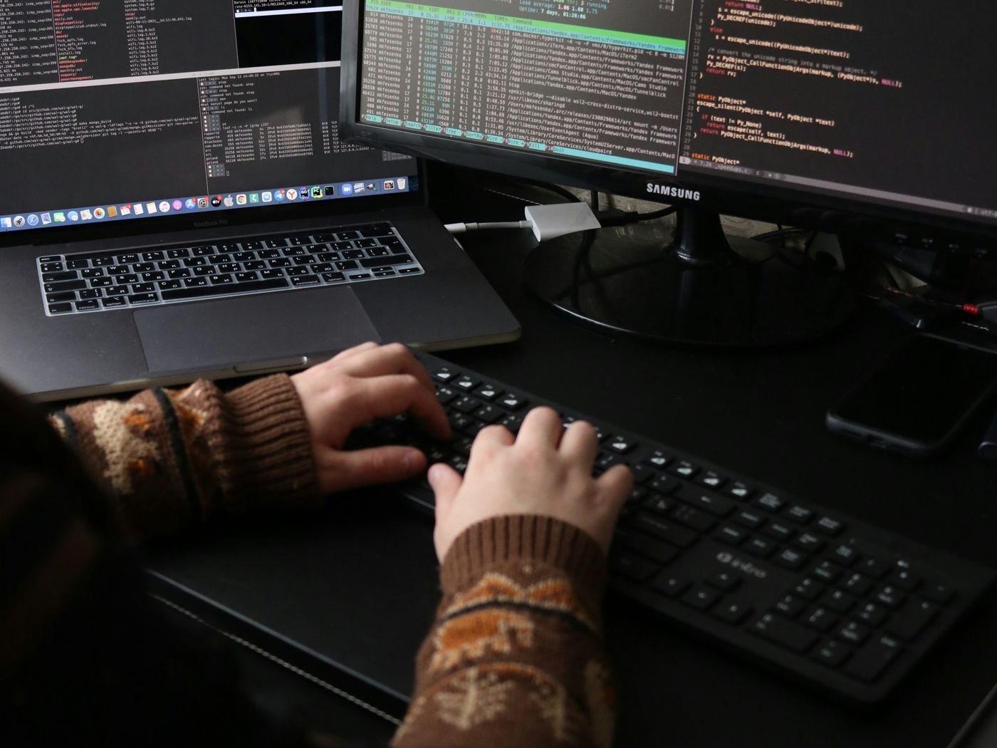 Entwickler an Tastatur und Bildschirmen mit Code